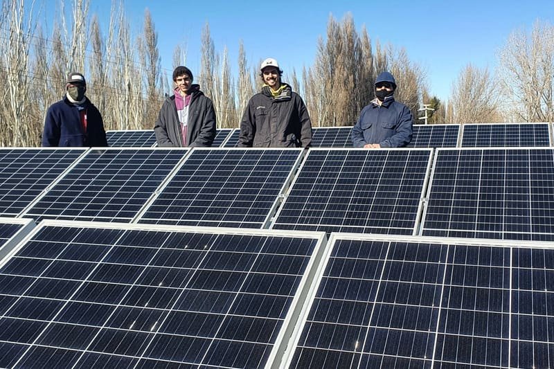 Equipo de trabajo detrás de las hileras de paneles solares