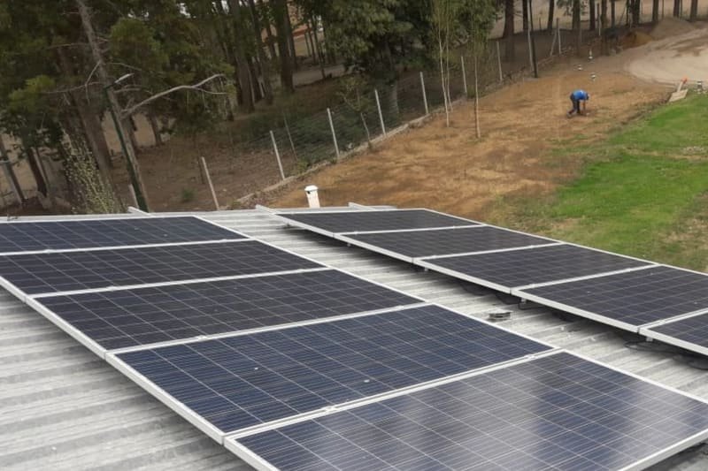 Paneles solares sobre el techo de chapa de la sede, durante el montaje